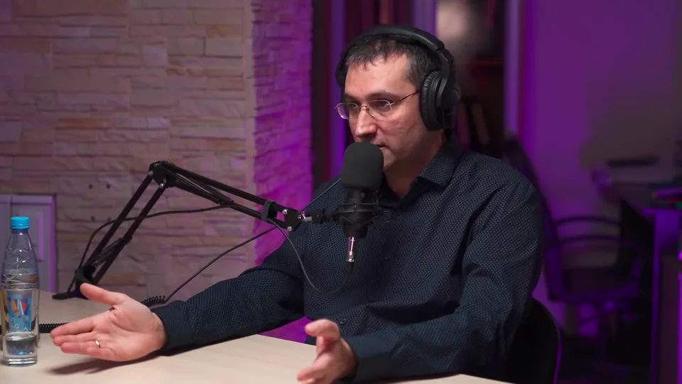 A guest in a dark shirt explaining at the table, January 2021
