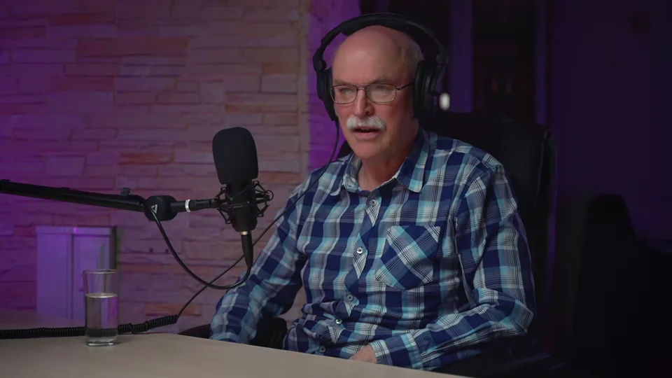 A guest in a checked shirt speaking into the microphone, June 2022